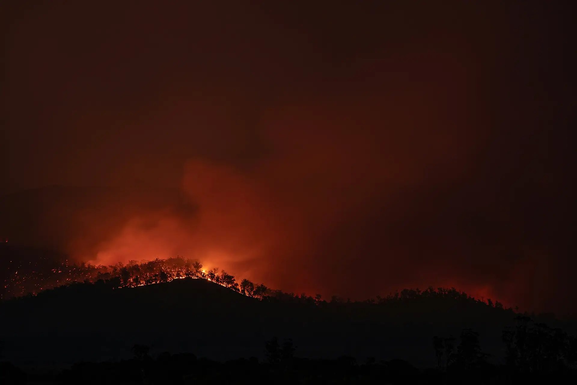 A bushfire burning along a ridgeline at night